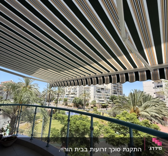 מרפסת עם סוכך בד פסים ונוף עירוני
